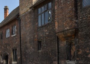 view of the external wall of Wash-House Court at the Charterhouse with symbols and lettering in the brickwork