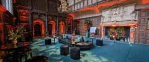 The Great Hall at the Charterhouse with a teal carpet and uplighting dressed for an event